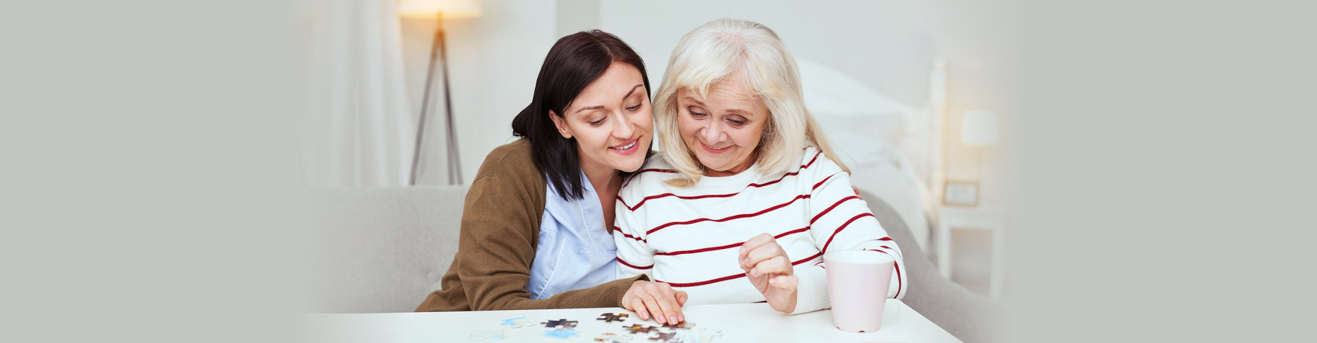 caregiver and senior woman playing with puzzles