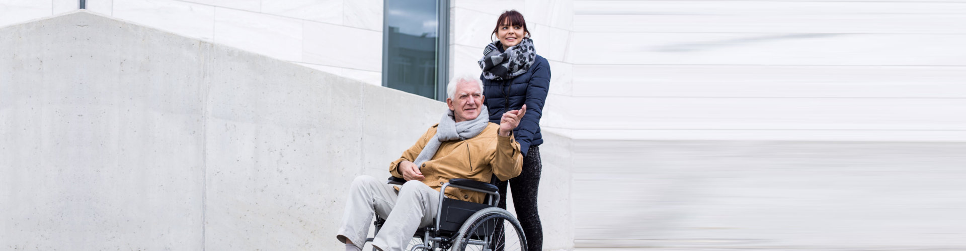 caregiver together with senior man on wheelchair