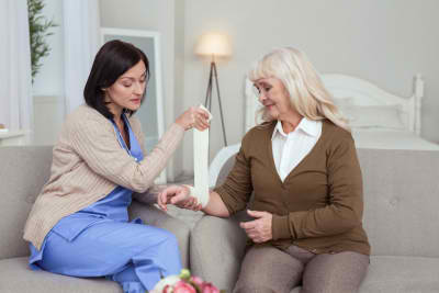 caregiver swathing elder woman hand