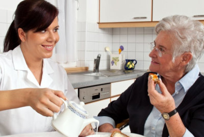 caregiver and senior woman eating